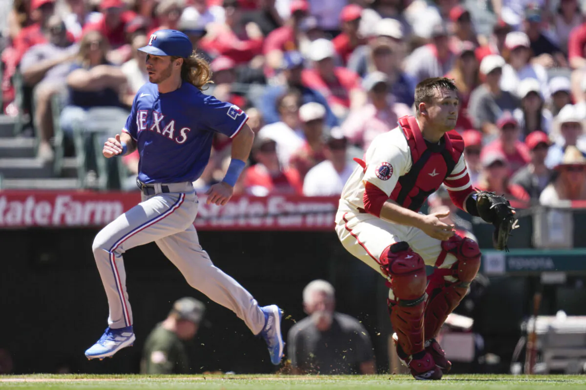 Texas Rangers' Travis Jankowski scores ahead of a throw to Los Angeles Angels catcher Matt Thaiss, right, during the second inning of a baseball game in Anaheim, Calif., on May 7, 2023. (Ashley Landis/AP Photo)