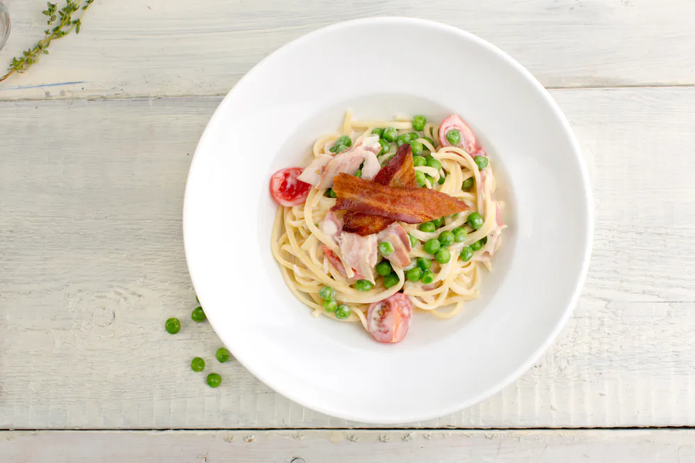 Pasta carbonara's trio of eggs, cheese, and noodles alchemize to create a glistening bowl of pasta that's as restorative as it is comforting.(Demkat/Shutterstock)