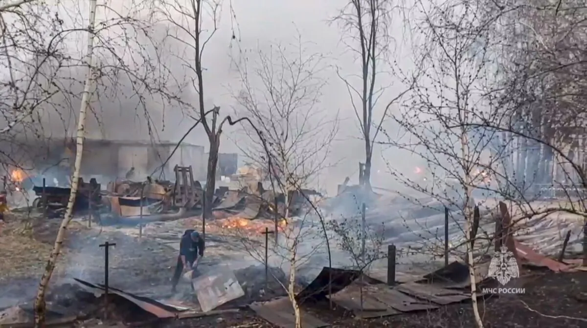 Russian Emergency Ministry employees and local citizens work at a side of fire in Tyumen region, Russia, in a handout photo released on May 8, 2023. (Russian Emergency Ministry Press Service via AP)