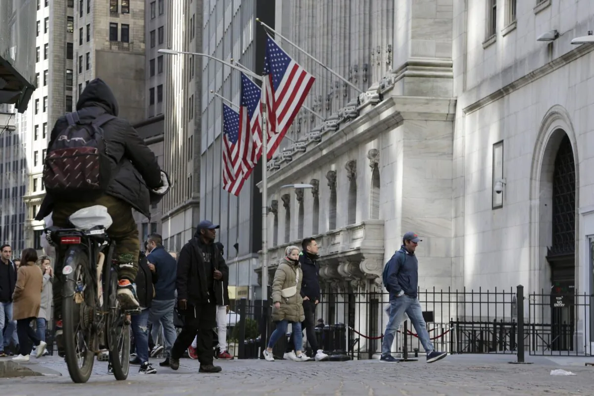 People pass the front of the New York Stock Exchange on March 21, 2023. (Peter Morgan/AP Photo)