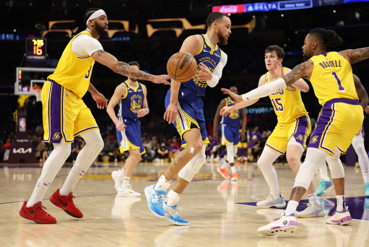 Stephen Curry (30) of the Golden State Warriors passes the ball between Anthony Davis (3) and D'Angelo Russell (1) of the Los Angeles Lakers during the third quarter in game four of the Western Conference Semifinal Playoffs in Los Angeles on May 8, 2023. (Harry How/Getty Images)