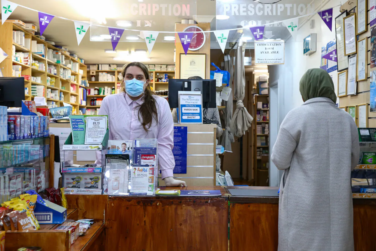 Pre-registration pharmacist Miron Farmus wears personal protective equipment while working at a pharmacy in Stroud Green, London, on April 14, 2020. (Hollie Adams/Getty Images)