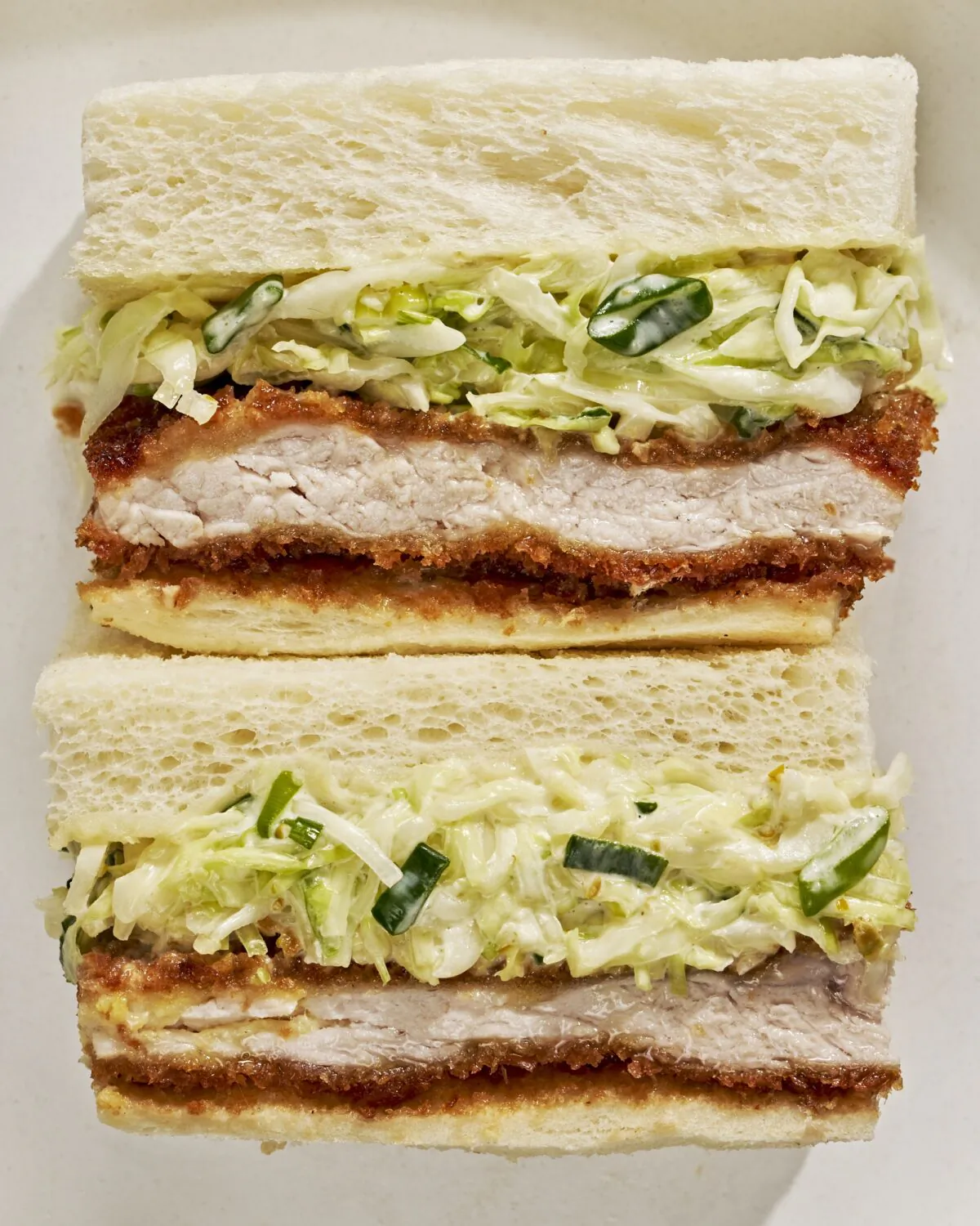 A crispy pork cutlet, kewpie mayonnaise, and thinly shredded cabbage is all sandwiched between slices of plush milk bread. (Andrew Bui/TNS)