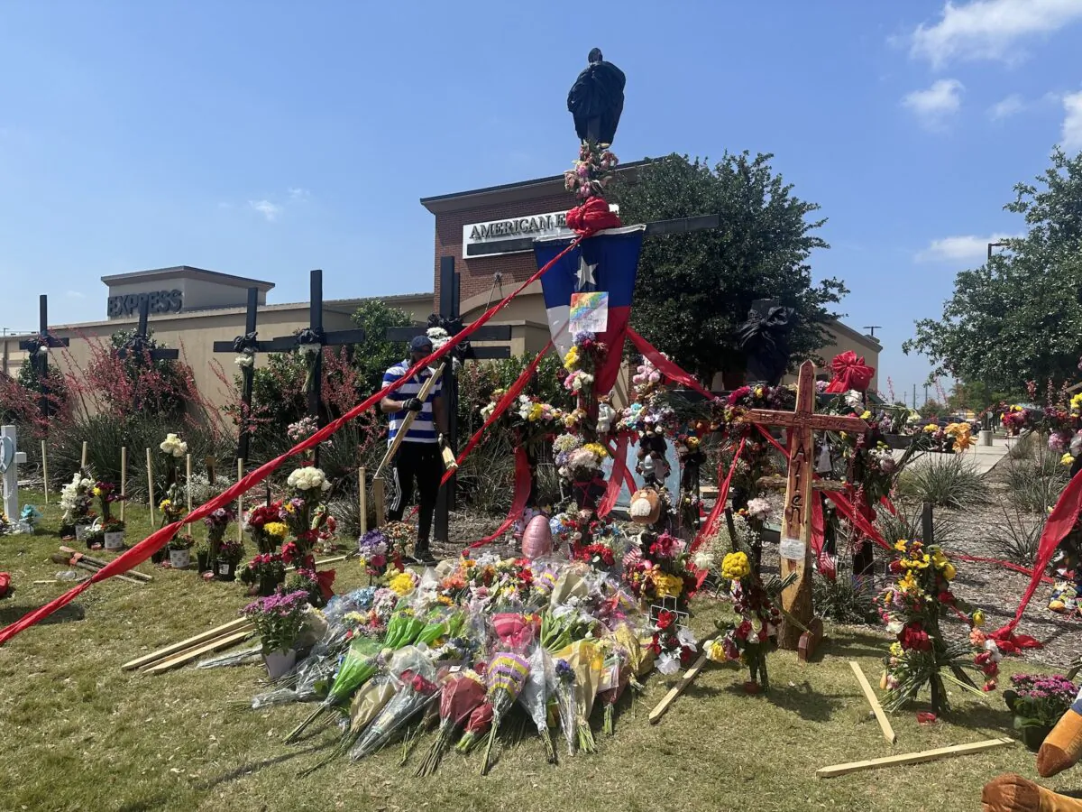 Minnie's Food Pantry Community Relations Manager Robert Jackson helps install crosses at the Allen Premium Outlet mall memorial site in Allen, Texas, on May 8, 2023. (Jana J. Pruet/The Epoch Times)