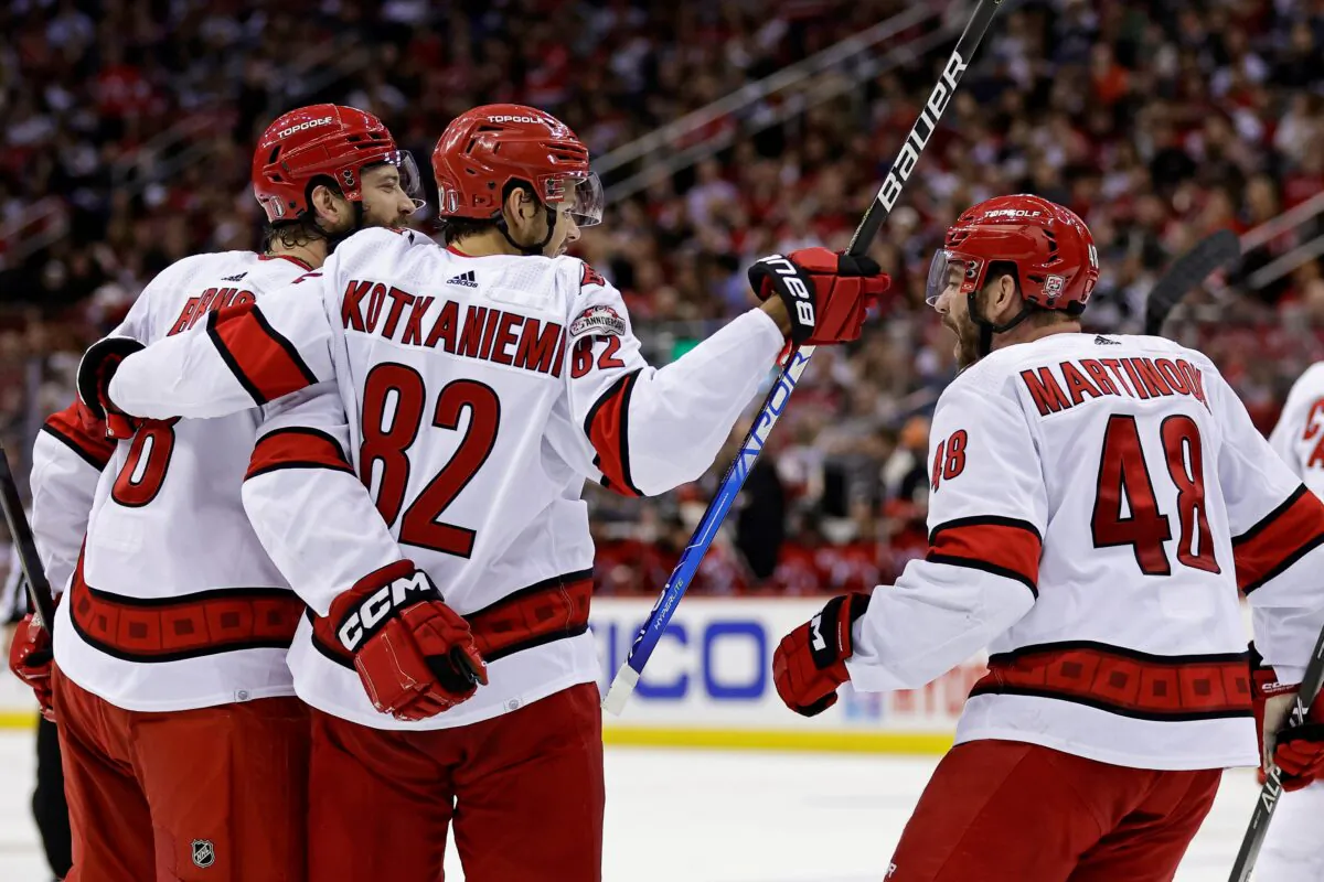 Carolina Hurricanes defenseman Brent Burns is congratulated by Jesperi Kotkaniemi (82) and Jordan Martinook (48) after scoring a goal against the New Jersey Devils during the second period of Game 4 of an NHL hockey Stanley Cup second-round playoff series in Newark, N.J., on May 9, 2023. (Adam Hunger/AP Photo)