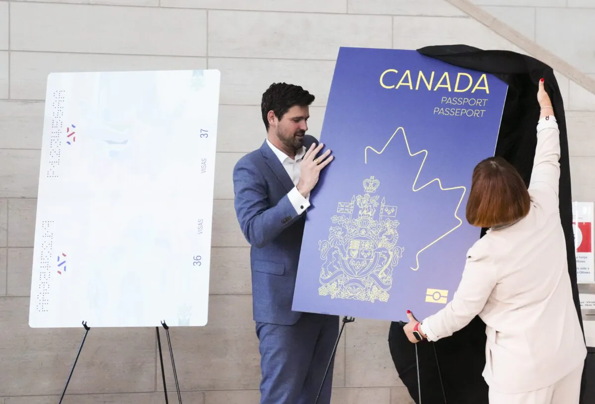 Sean Fraser, Minister of Immigration, Refugees and Citizenship, and Marie-France Lalonde, Parliamentary Secretary to the Minister of Immigration, Refugees and Citizenship unveil the new Canadian passport at the Ottawa International Airport in Ottawa on May 10, 2023. (THE CANADIAN PRESS/Sean Kilpatrick)