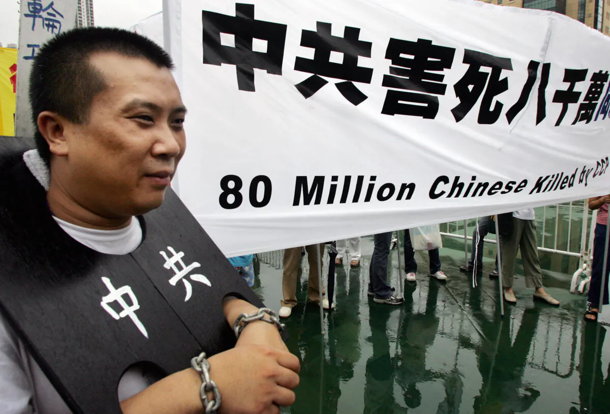 A protester shows how prisoners are treated and paraded in public in China, during a rally in Hong Kong, on July 31, 2005. (Ted Aljibe/AFP via Getty Images)
