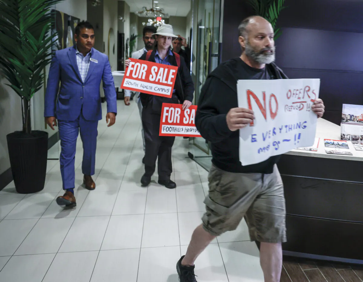Protesters are escorted from the building after disrupting United Conservative Party Leader Danielle Smith's campaign announcement in Calgary, Alta., on May 11, 2023. (Jeff McIntosh/The Canadian Press)