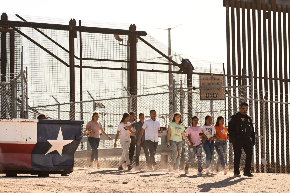 Illegal immigrants board vans after waiting along the border wall to surrender to U.S. Customs and Border Protection (CBP) Border Patrol agents for immigration and asylum claim processing upon crossing the Rio Grande river into the United States on the U.S.-Mexico border in El Paso, Texas, on May 11, 2023. (Patrick T. Fallon/AFP via Getty Images)