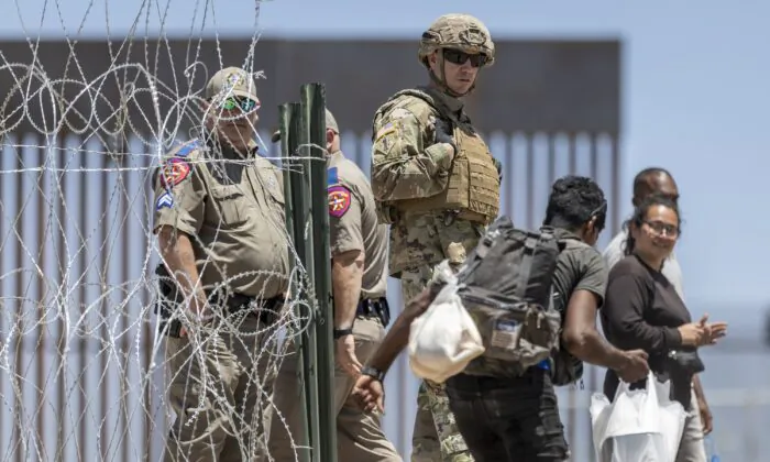 A Texas National Guard soldier watches as a migrant walks into a makeshift migrant camp in El Paso, Texas, on May 11, 2023. (John Moore/Getty Images)