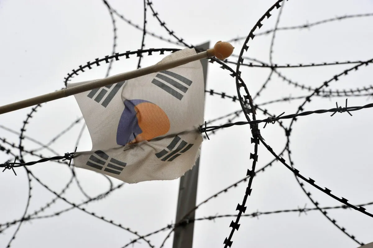 A South Korean flag hanging on a military barbed wire fence flutters at Imjingak peace park near the Demilitarized Zone (DMZ) dividing the two Koreas in the border city of Paju on April 16, 2013. (Jung Yeon-je/AFP via Getty Images)