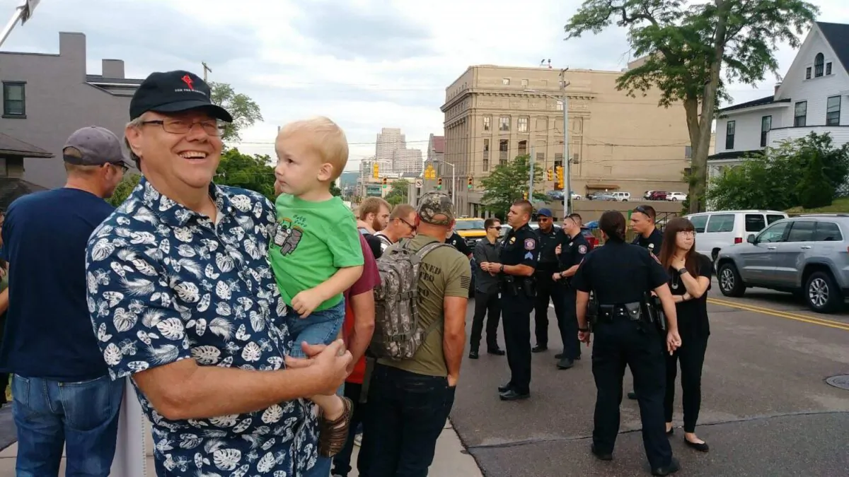 Standing on a sidewalk in front of an abortion facility, Calvin Zastrow holds his grandson in his arms in Grand Rapids, Michigan on July, 13, 2022. (Courtesy Cal Zastrow)