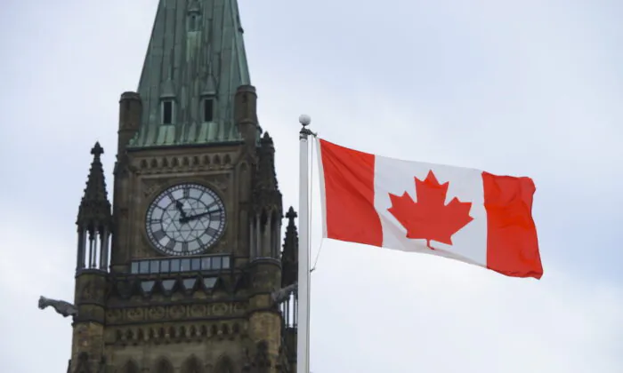 A Canadian flag flies by Parliament Hill in Ottawa on March 13, 2020. (Sean Kilpatrick/The Canadian Press)