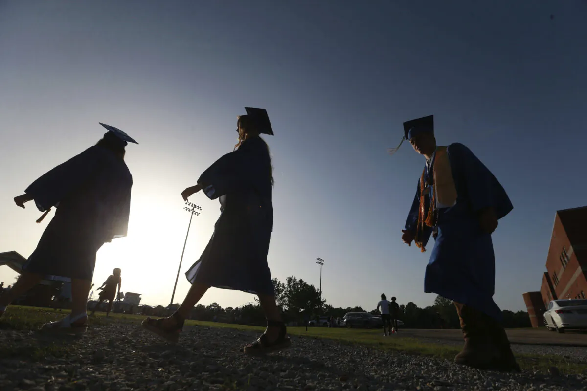 High School seniors make their way to the football field as the sun begins to set for their graduation ceremony in Saltillo, Miss., June 27, 2020. (Thomas Wells/The Northeast Mississippi Daily Journal via AP)
