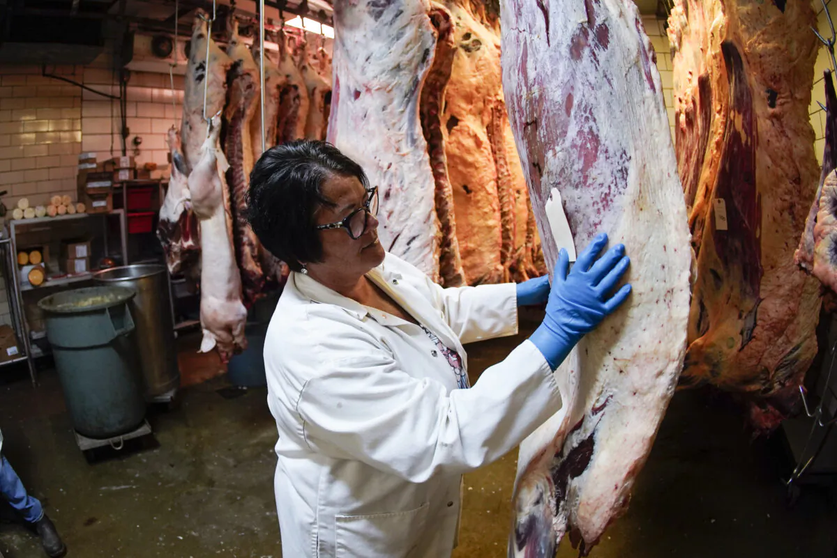 Stacey Richard checks sides of beef hanging in the refrigerated butchering section at the Wright's Meat Packing facility in Fombell, Pa., on June 16, 2022. (Keith Srakocic/AP Photo)