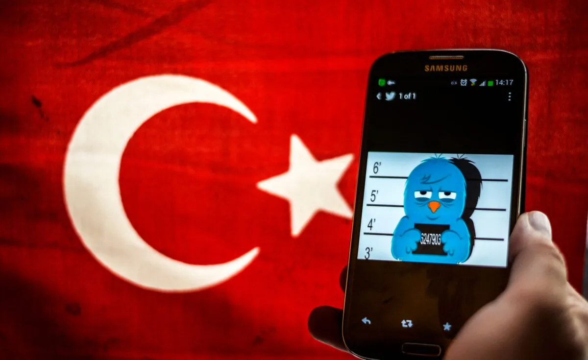 A picture representing a mugshot of the Twitter bird is seen on a smartphone with a Turkish flag on March 26, 2014. (Ozan Kose/AFP via Getty Images)