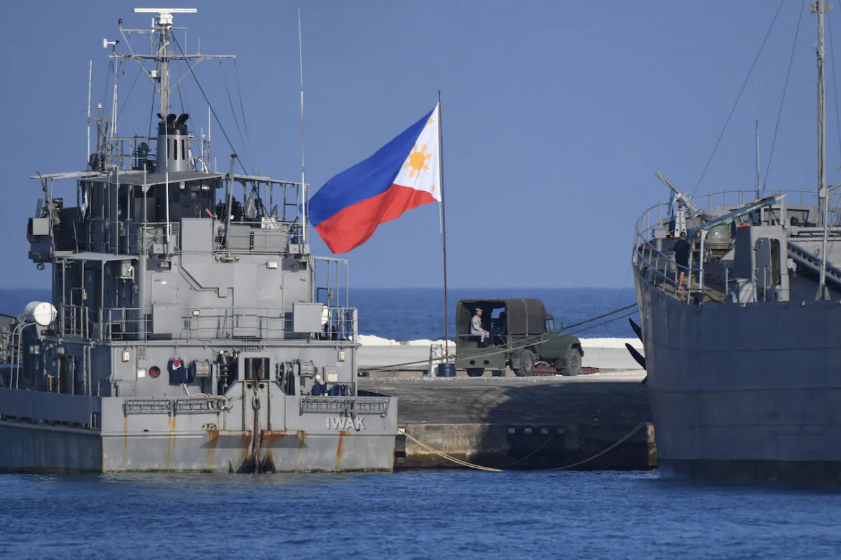 A Philippine flag flutters next to navy ships anchored at the Philippine-occupied Thitu island in the disputed South China Sea, on April 21, 2023.(TED ALJIBE/AFP via Getty Images)