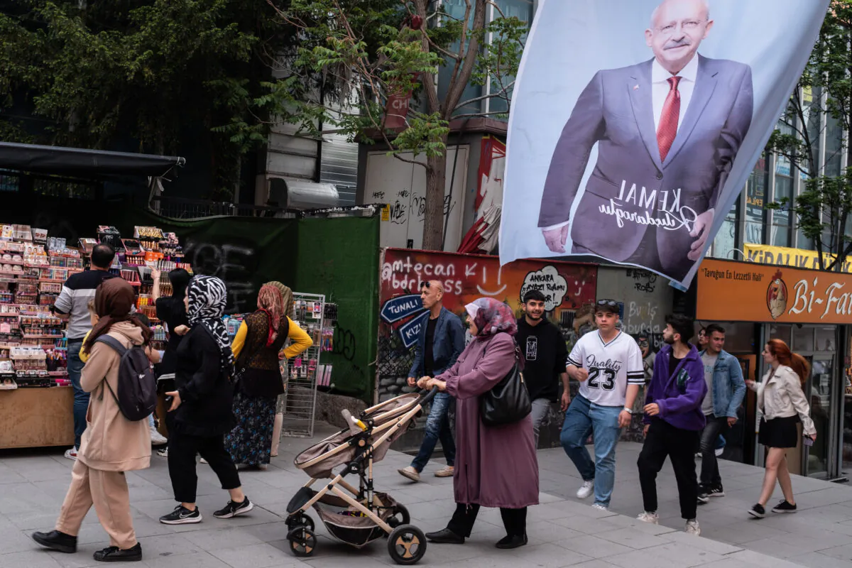 People walk under the posters of Kemal Kilicdaroglu, the presidential candidate of the main opposition alliance in Ankara, Turkey, on May 15, 2023. (Burak Kara/Getty Images)