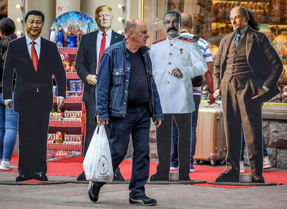 A man walks past cardboard cutouts of Chinese President Xi Jinping, US President Donald Trump, Soviet leaders Joseph Stalin and Vladimir Lenin in downtown Moscow on Aug. 7, 2019. (Yuri Kadobnov/AFP via Getty Images)