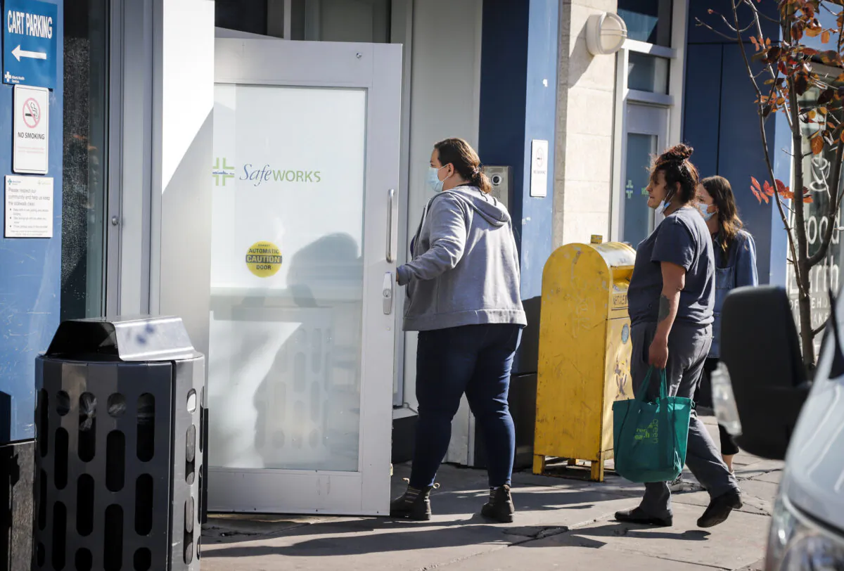 People wait to enter the Safeworks supervised consumption site at the Sheldon M. Chumir Health Centre in Calgary, Alta., on Aug. 26, 2021. (Jeff McIntosh/The Canadian Press)