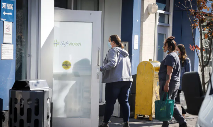 People wait to enter the Safeworks supervised consumption site at the Sheldon M. Chumir Health Centre in Calgary, Alta., on Aug. 26, 2021. (Jeff McIntosh/The Canadian Press)