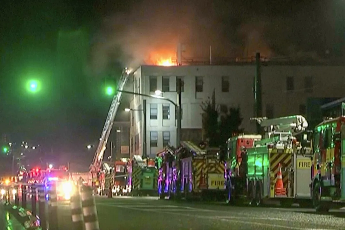 In this image made from video, firetrucks stage outside a hostel in central Wellington, New Zealand, on May 16, 2023. (NewsHub via AP)