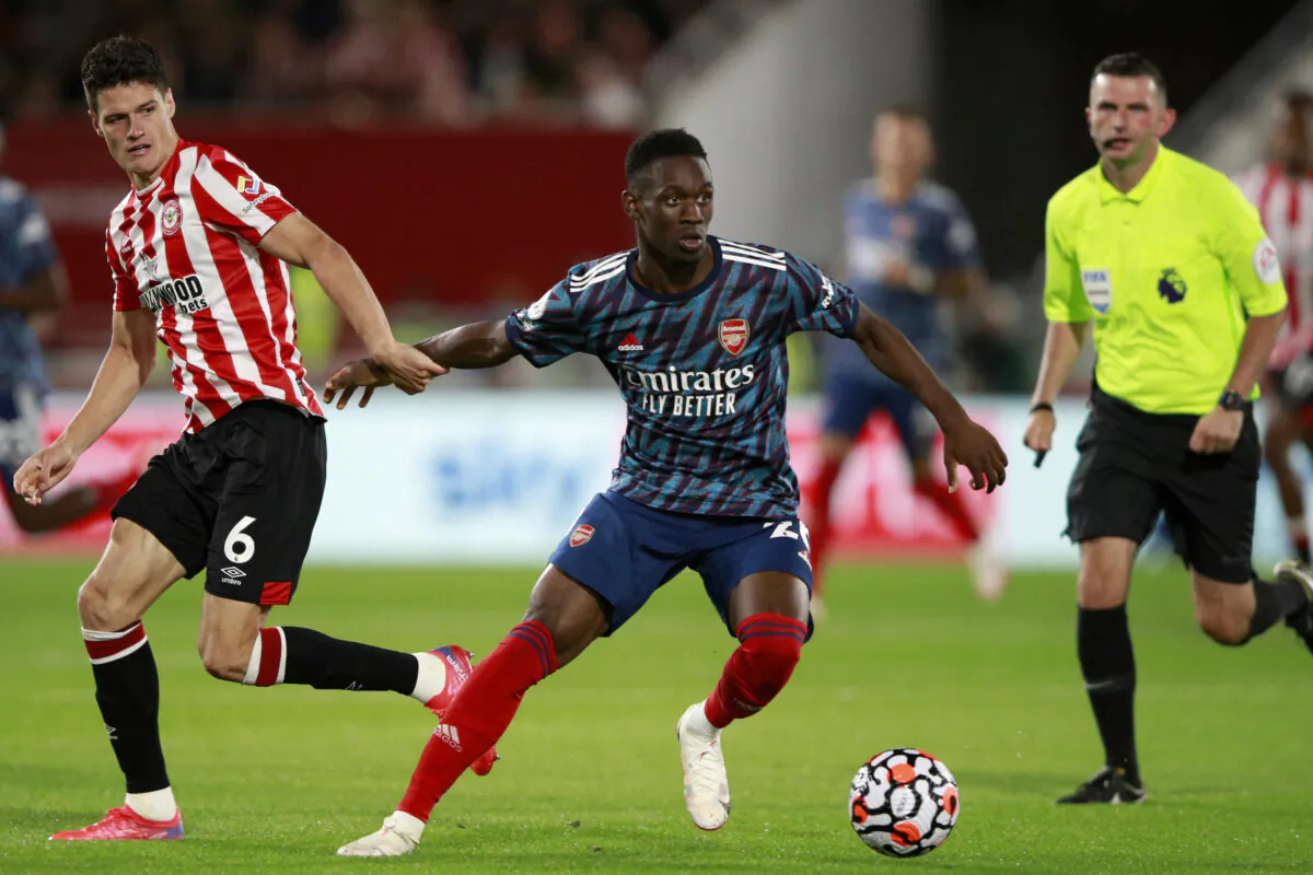 Brentford's Christian Norgaard vies for the ball with Arsenal's Folarin Balogun, center, during the English Premier League soccer match between Brentford and Arsenal at the Brentford Community Stadium in London, on Aug. 13, 2021. (Ian Walton/AP Photo)