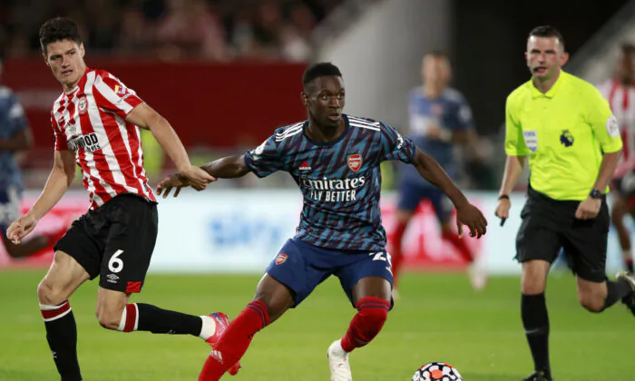 Brentford's Christian Norgaard vies for the ball with Arsenal's Folarin Balogun, center, during the English Premier League soccer match between Brentford and Arsenal at the Brentford Community Stadium in London, on Aug. 13, 2021. (Ian Walton/AP Photo)
