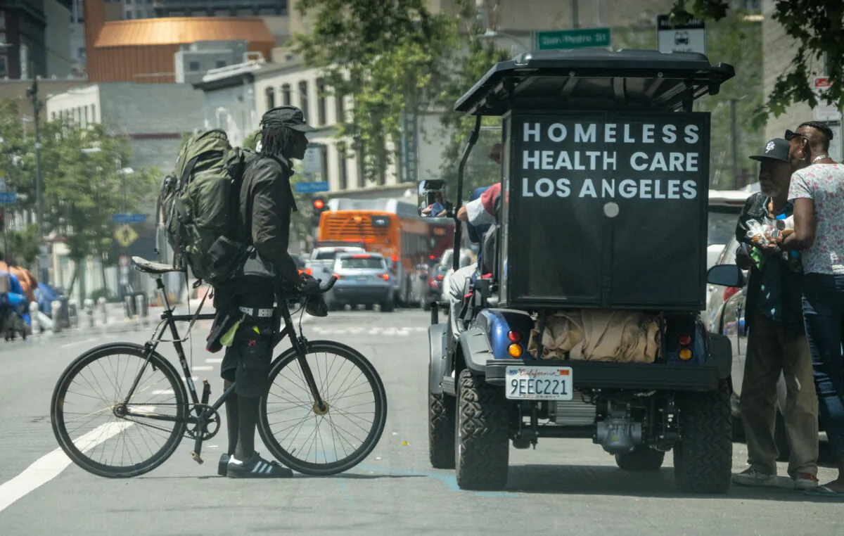 Homeless Health Care Los Angeles workers distribute items in the Skid Row neighborhood of Los Angeles on May 16, 2023. (John Fredricks/The Epoch Times)