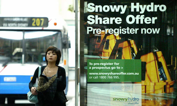 A woman passes by an advertisement of Snowy Hydro share initial public offering (IPO) in Sydney, 02 June 2006. (David Hancock/AFP via Getty Images)