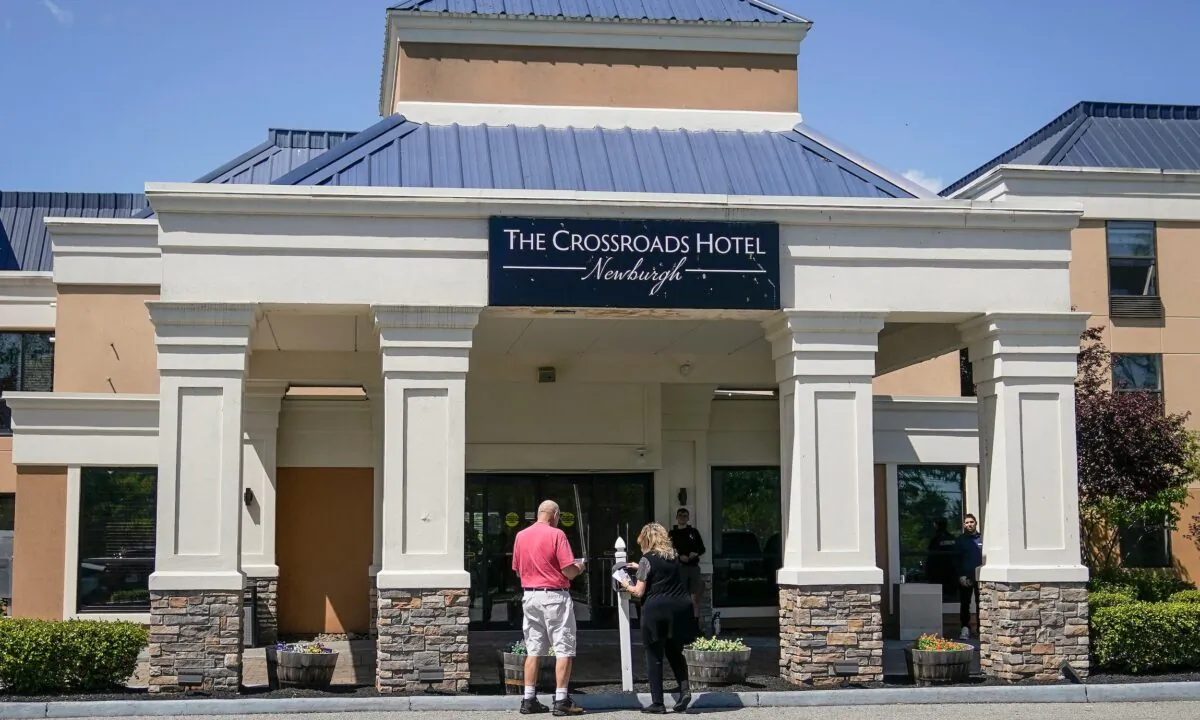 Security stands at the doors of The Crossroads Hotel, where two busloads of illegal immigrants arrived hours earlier in Newburgh, N.Y., on May 11, 2023. (John Minchillo/AP Photo)