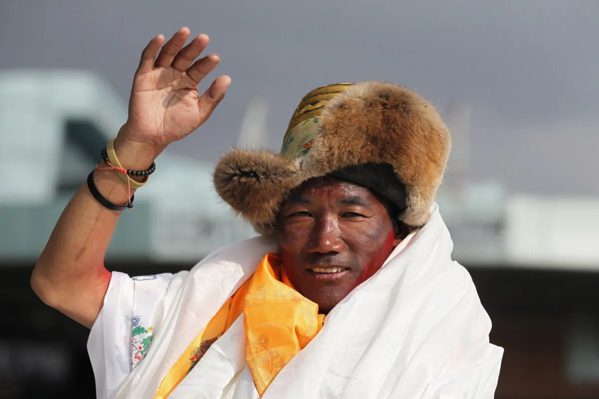 Nepalese veteran Sherpa guide Kami Rita waves as he arrives in Kathmandu, Nepal, on May 20, 2018. (Niranjan Shrestha/AP Photo)
