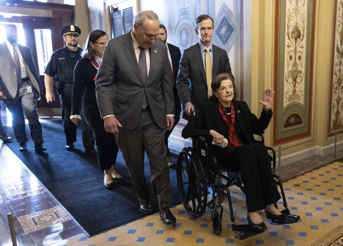 U.S. Senate Majority Leader Chuck Schumer (D-N.Y.) escorts Sen. Dianne Feinstein (D-Calif.) as she arrives at the U.S. Capitol following a long absence due to health issues in Washington, on May 10, 2023. (Kevin Dietsch/Getty Images)