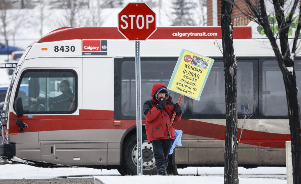 A protestor maintains a 100 meter distance from a drag queen story hour being held at a public library in Calgary, Alberta on Monday, March 27, 2023. Under a bylaw, certain protests are not allowed. (Jeff McIntosh/The Canadian Press)