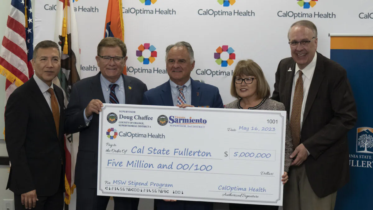 Officials from CalOptima, which offers public health insurance in Orange County, present a $5 million check to California State University–Fullerton to support students pursuing a master’s degree in the school’s social worker program at a press conference in Fullerton, Calif., on May 15, 2023. (Courtesy of CalOptima)