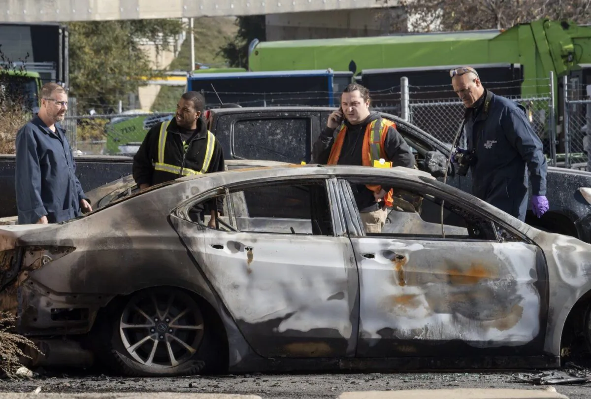 A police arson inspector looks over burned cars at a lot In Montreal, Que., Nov. 4, 2022. (The Canadian Press/Ryan Remiorz)

