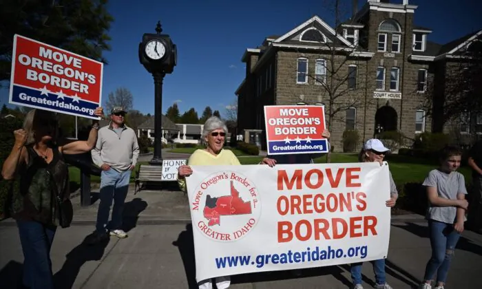 People hold signs in favor of the Greater Idaho Movement in Enterprise, Ore., on May 12, 2023. (Robyn Beck/AFP via Getty Images)