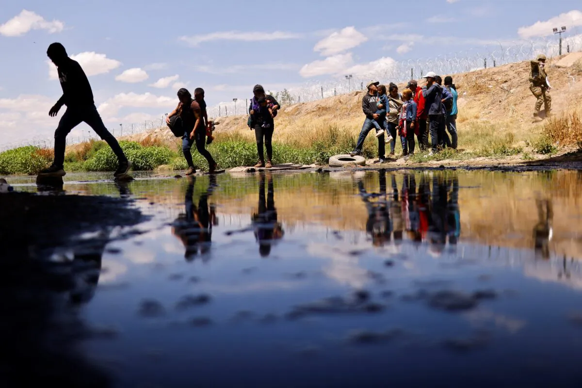 Immigrants seeking asylum cross the Rio Bravo to return to Mexico from the United States, after members of the U.S. Texas National Guard extended razor wire to inhibit migrant crossing, as seen from Ciudad Juarez, Mexico, on May 13, 2023. (Jose Luis Gonzalez/Reuters)