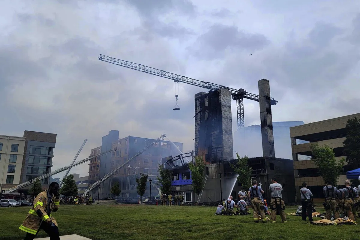 Firefighters work the scene of a massive fire spread across at least two structures and threatened others in Charlotte's South Park neighborhood, N.C., on May 18, 2023. (Khadejh Nikouyeh/The Charlotte Observer via AP)