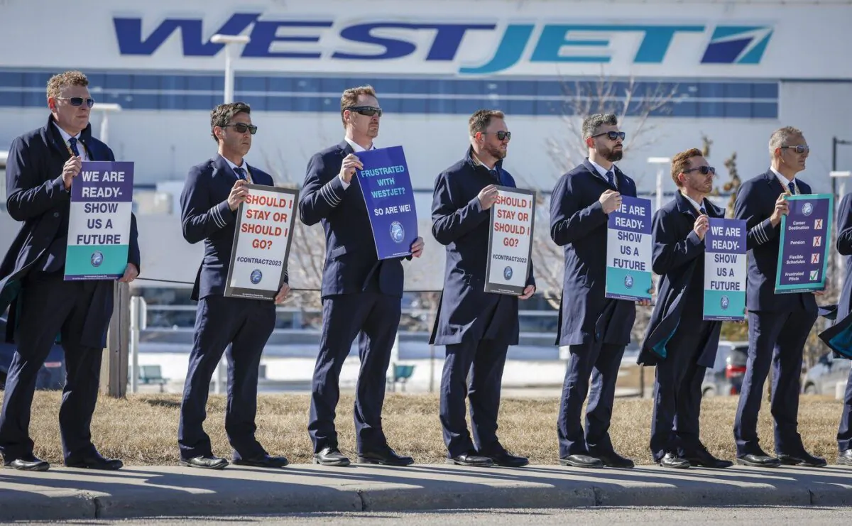 Members of the Air Line Pilots Association demonstrate amid contract negotiations outside the WestJet headquarters in Calgary, Alta., Mar. 31, 2023. (The Canadian Press/Jeff McIntosh)
