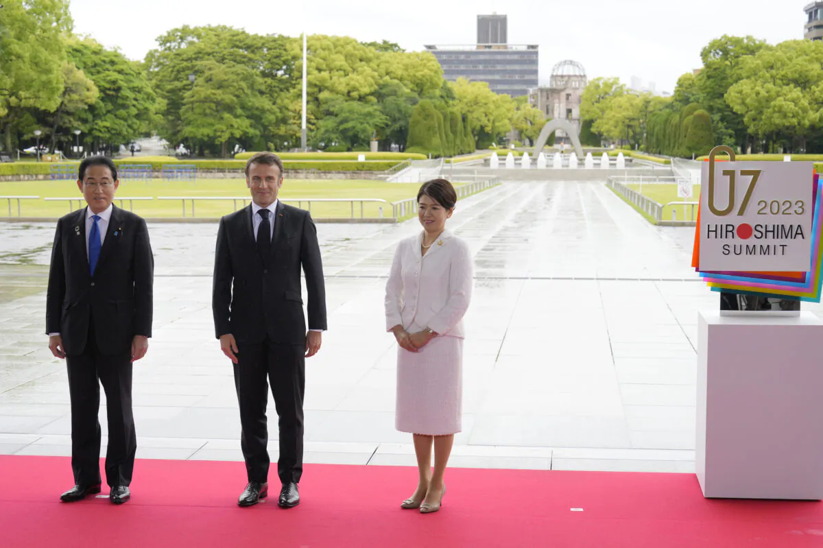 French President Emmanuel Macron (C) is welcomed by Japanese Prime Minister Fumio Kishida and First Lady Yuko Kishida during a visit to the Peace Memorial Park on the sidelines of the G-7 summit in Hiroshima, Japan, on May 19, 2023. The G-7 summit will be held in Hiroshima from May 19–22. (Franck Robichon/Pool/Getty Images)