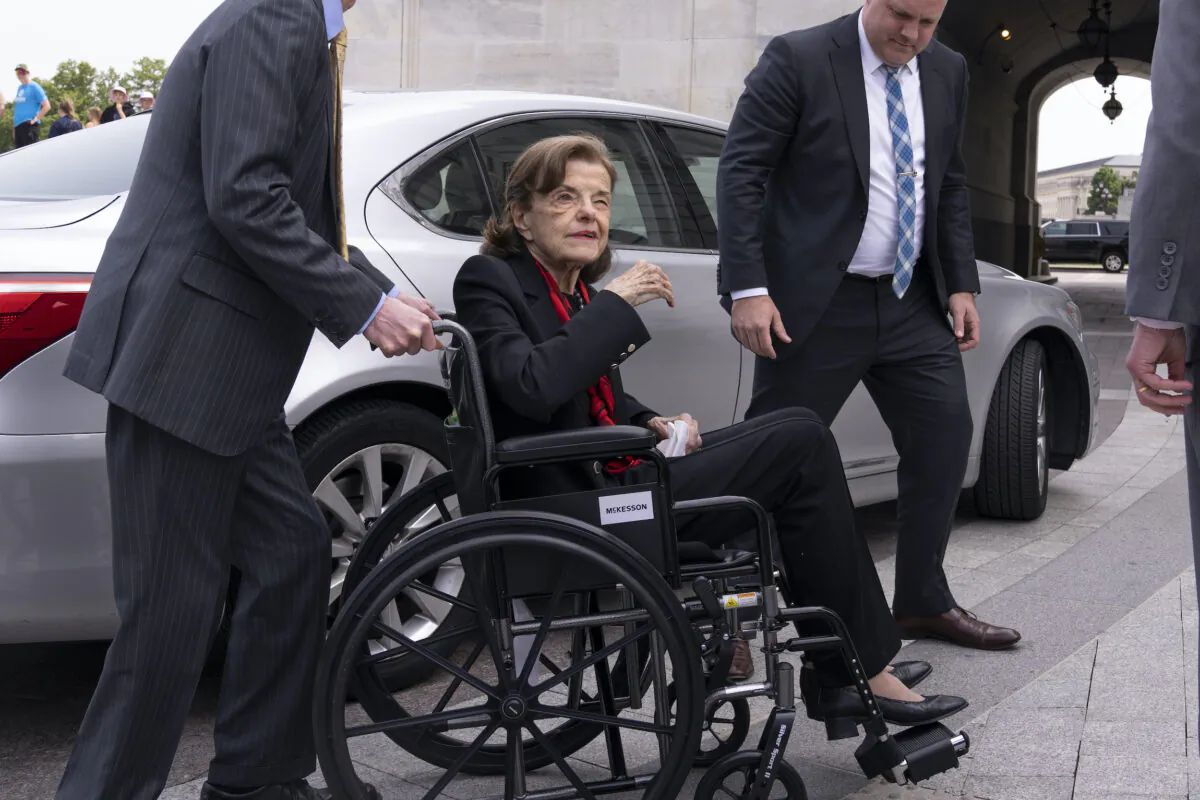 Sen. Dianne Feinstein (D-Calif.) is assisted to a wheelchair by staff as she returns to the Senate after a months-long absence, at the Capitol on May 10, 2023. (J. Scott Applewhite/AP Photo)