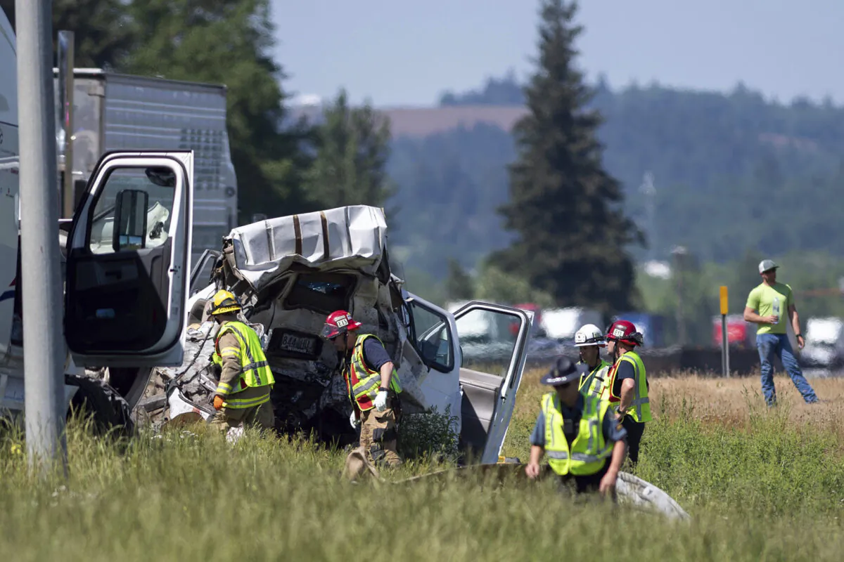 Oregon State Police troopers and firefighters work near the site of a wrecked tractor-trailer along Interstate 5 in Albany, Ore., on May 18, 2023. (Alex Powers/Albany Democrat-Herald via AP)