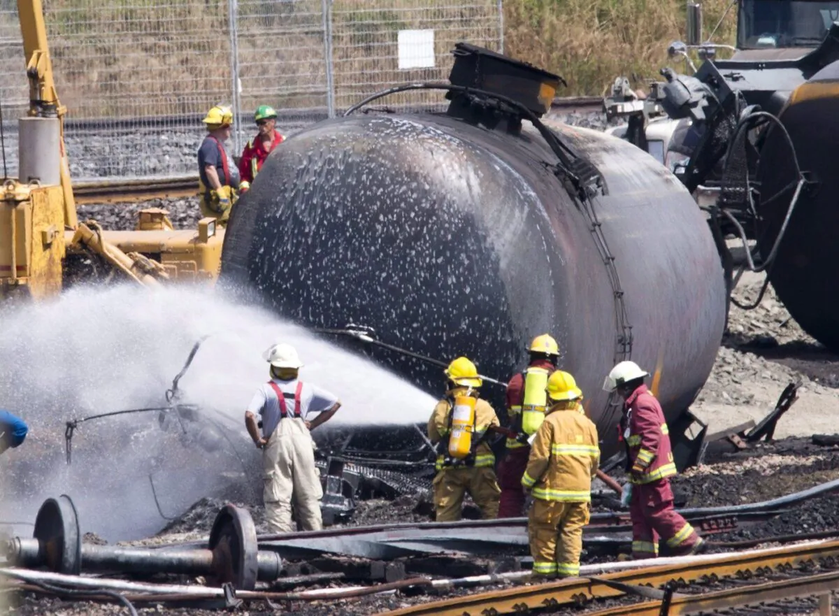 Firefighters spray foam on the train crash site in Lac-Megantic, Que., July 14, 2013. (The Canadian Press/Jacques Boissinot)