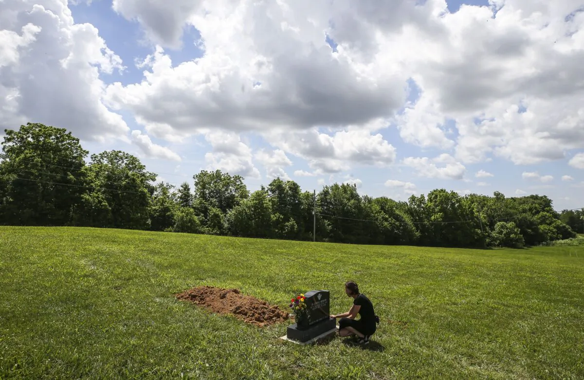 Kelly Vervillas, of Shepherdsville, Ky., visits the gravesite of the unknown boy who was found in a suitcase in April 2022 in Washington County in Salem, Ind., on June 1, 2022. (Matt Stone/Courier Journal via AP)