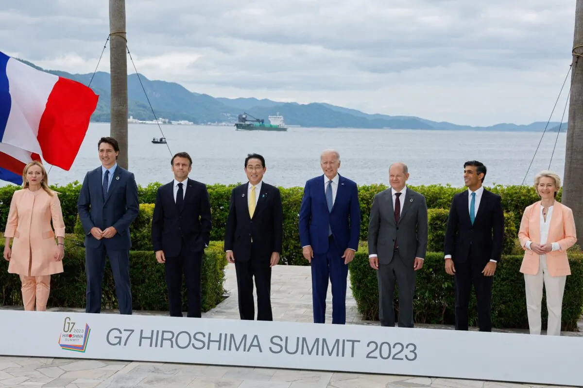 (L-R) Italy's Primer Minister Giorgia Meloni, Canada's Prime Minister Justin Trudeau, France's President Emmanuel Macron, Japan's Prime Minister Fumio Kishida, U.S. President Joe Biden, German Chancellor Olaf Scholz, Britain's Prime Minister Rishi Sunak, and European Commission President Ursula von der Leyen participate in a family photo with G7 leaders before their working lunch meeting on economic security at the Grand Prince Hotel in Hiroshima, Japan, on May 20, 2023. (Jonathan Ernst/Pool/AFP via Getty Images)