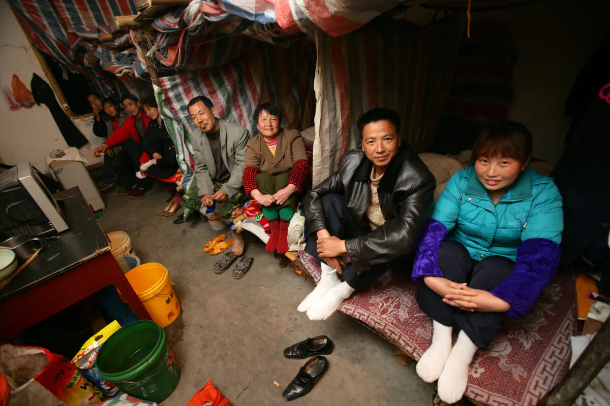 Four migrant worker couples sit in their shelters made out of plastic sheeting, at a road construction site in Chongqing, China on March 5, 2008. (China Photos/Getty Images)