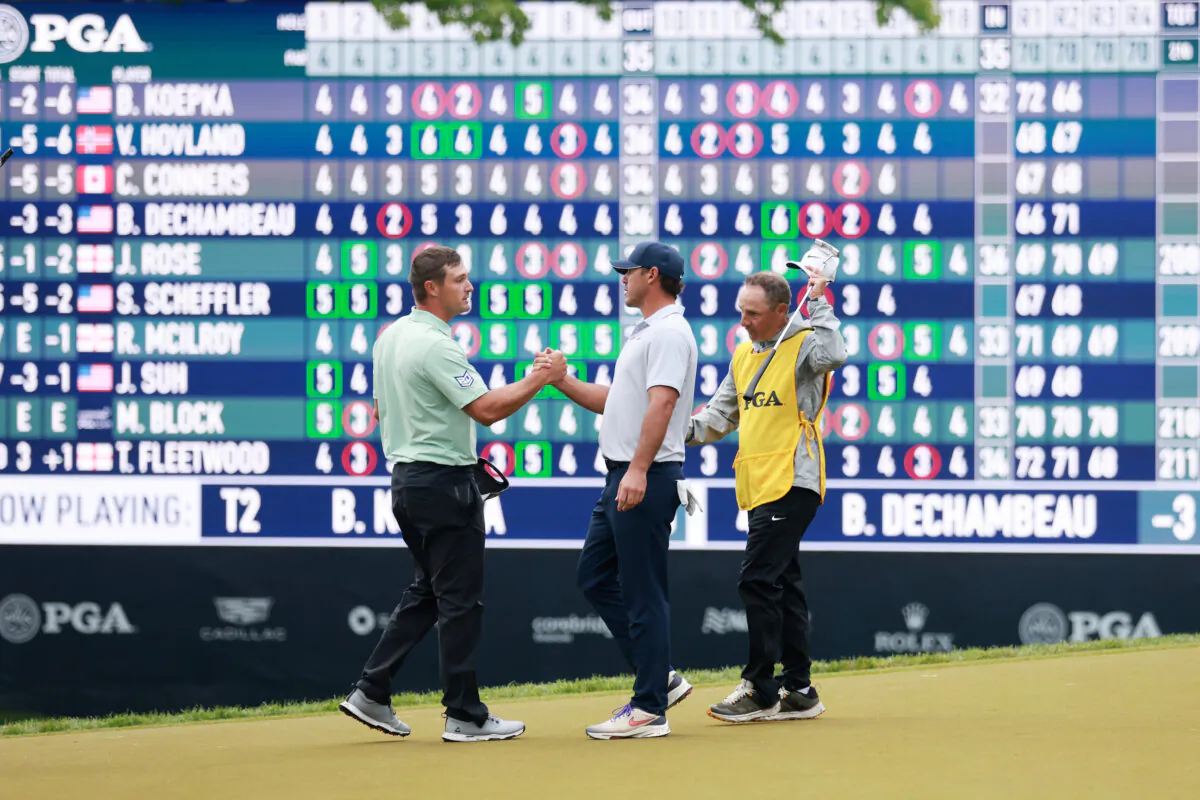 Bryson DeChambeau of the United States and Brooks Koepka of the United States shake hands on the 18th green during the third round of the 2023 PGA Championship at Oak Hill Country Club in Rochester, N.Y., on May 20, 2023. (Warren Little/Getty Images)