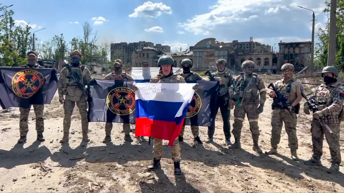 Yevgeny Prigozhin, the head of the Wagner Group military company, holds a Russian national flag in front of his soldiers in Bakhmut, Ukraine, in a still from video released on May 20, 2023. (Prigozhin Press Service via AP)