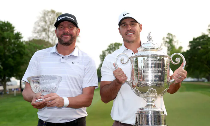 Michael Block (L), (club pro. of Arroyo Trabuco in Mission Viejo, Calif)., PGA of America Club Professional, celebrates alongside Brooks Koepka (R) of the United States hoisting the Wanamaker Trophy after winning the 2023 PGA Championship at Oak Hill Country Club in Rochester, N.Y., on May 21, 2023. (Warren Little/Getty Images)